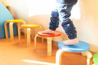 Balancieren über bunte Hocker