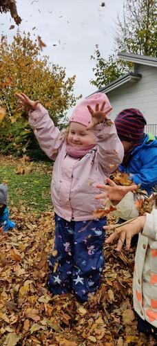 Kinder spielen mit Herbstblättern